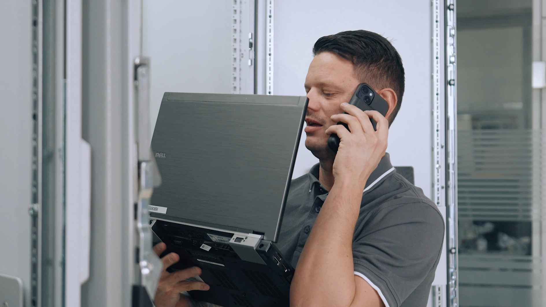 Servicetechniker arbeitet mit Laptop und Telefon am Schaltschrank – magnetische Notebook-Halterung MagFlex Pro von NBH-Systems